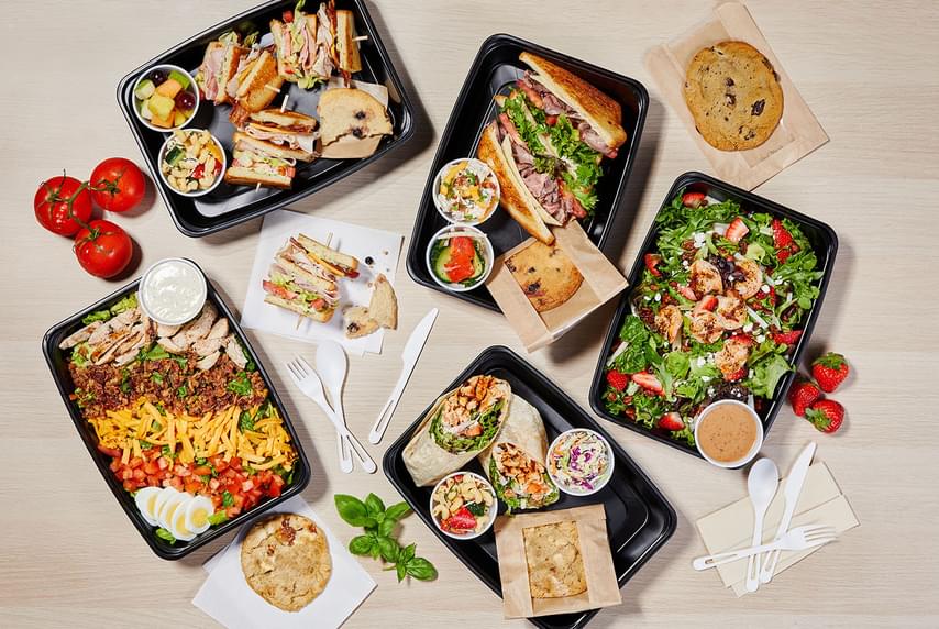 Five platters of Firebirds catered meals spread on a table.