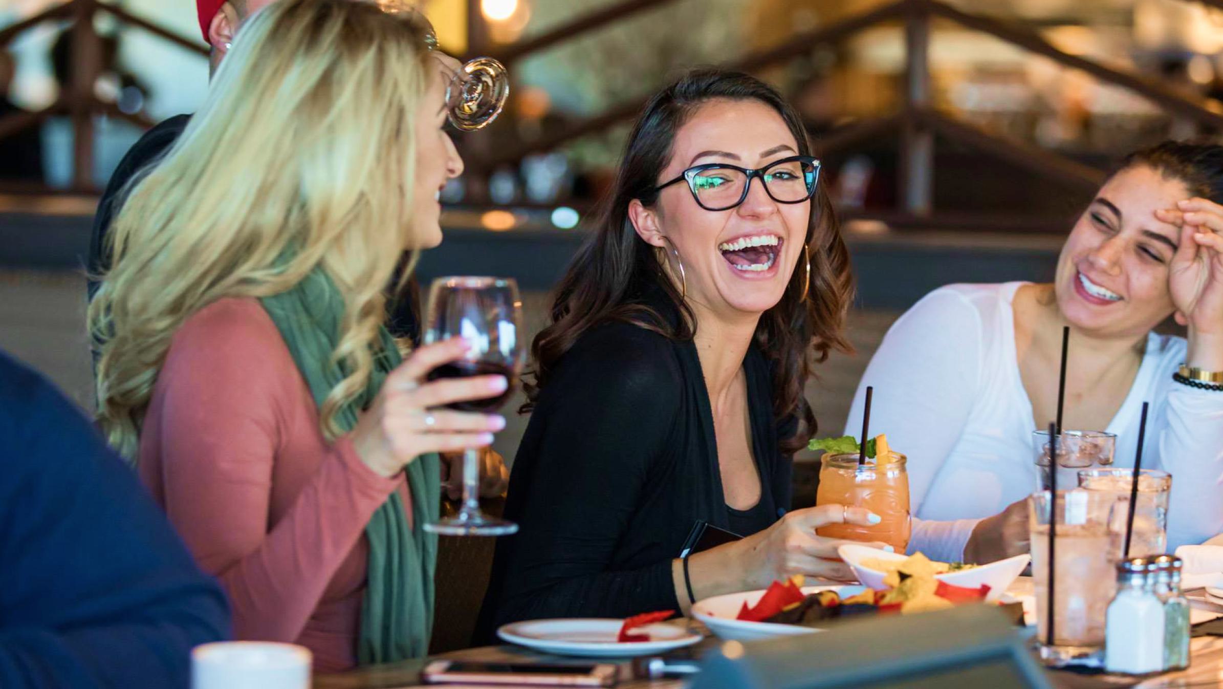 Three women at a table at Firebirds restaurants.